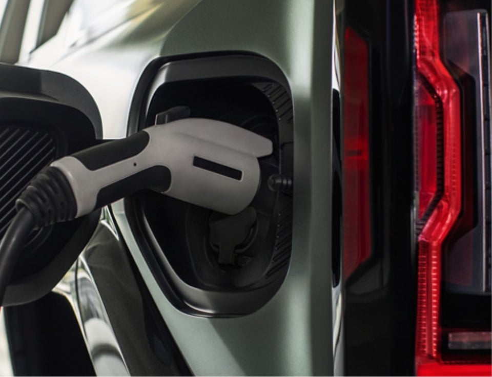 Close up of charging port with charger plugged in on a GMC Hummer EV SUV - Koons GMC Tysons in VIENNA VA